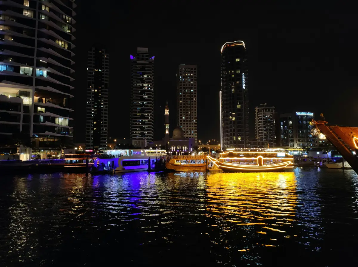 Dubai Marina bei Nacht mit beleuchteten Türmen und Yachthafen